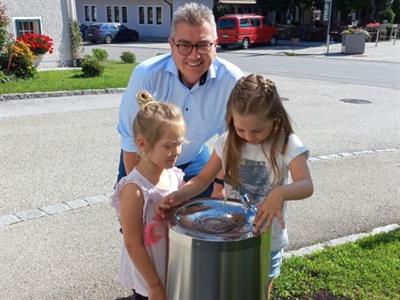 Bürgermeister Dörflinger mit zwei Mädchen beim neuen Brunnen