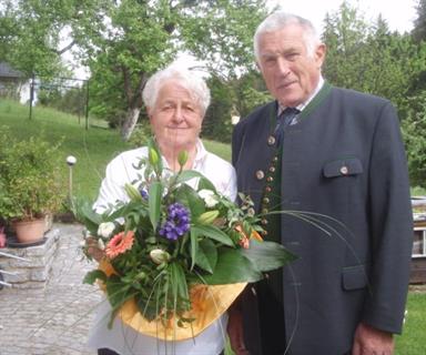 ein Mann und eine Frau, die vor einer Blume stehen